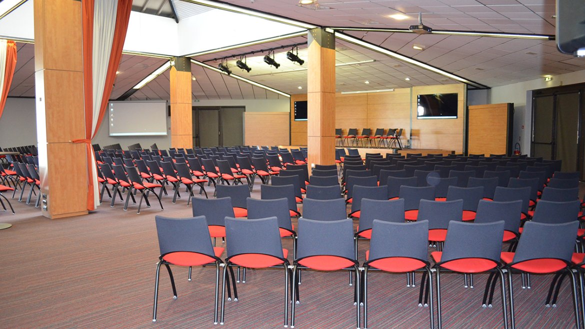 salle spacieuse avec scène et chaises format conférence